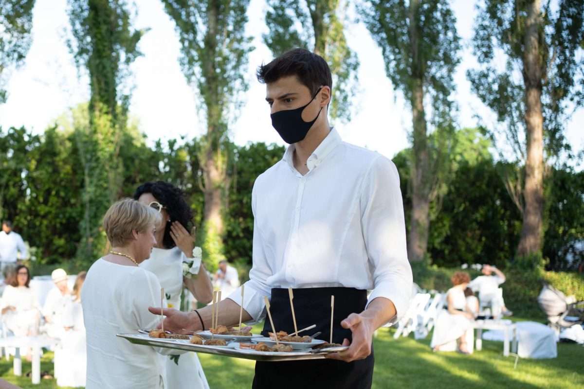 Primo piano di una cameriere durante un matrimonio che sta indossando mascherina - Matrimoni e Covid-19