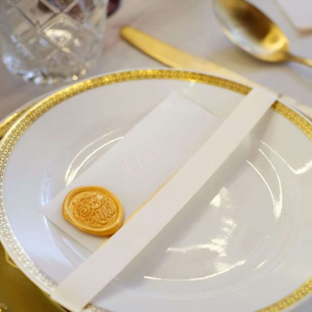 wedding planner Maria Mayer primo piano di piatto in porcellana bianca con decori dorati e posate dorate