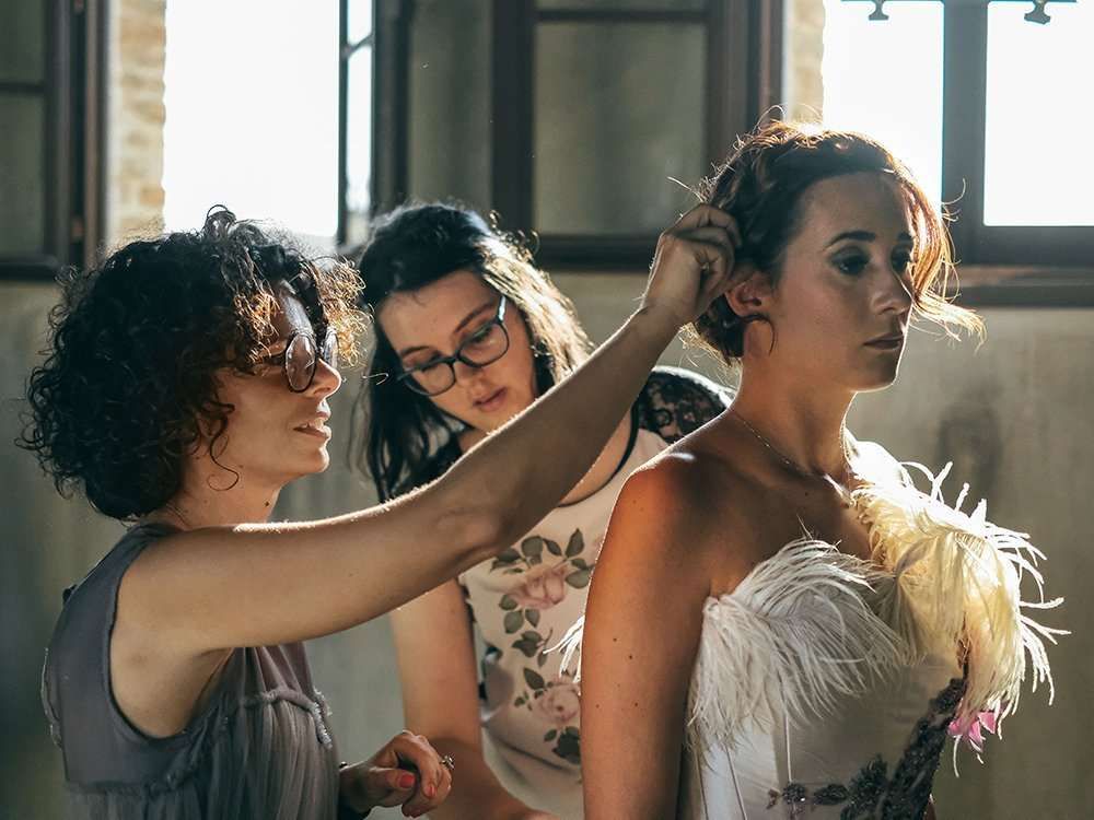 Organizzatore di matrimoni Maria Mayer foto di Maria che sistema i capelli ad una sposa prima della cerimonia