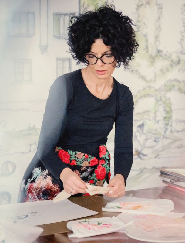 Organizzatore di matrimoni Maria Mayer durante i preparativi del matrimonio estivo a colori attorniata da tantissimi nastri colorati che scendono sul tavolo