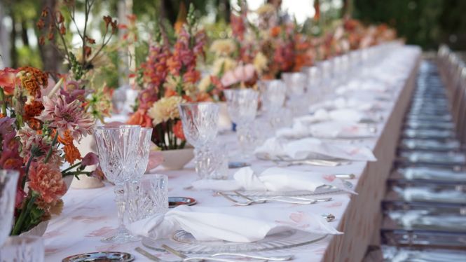 Foto nei toni dell'oro, di una stanza con arredamento lussuoso ed antico, la sposa in abito bianco e bouquet in mano &egrave; seduta su una poltrona nella parte destra della foto e guarda verso destra - Maria Mayer wedding & event designer a Treviso, Veneto, Italia